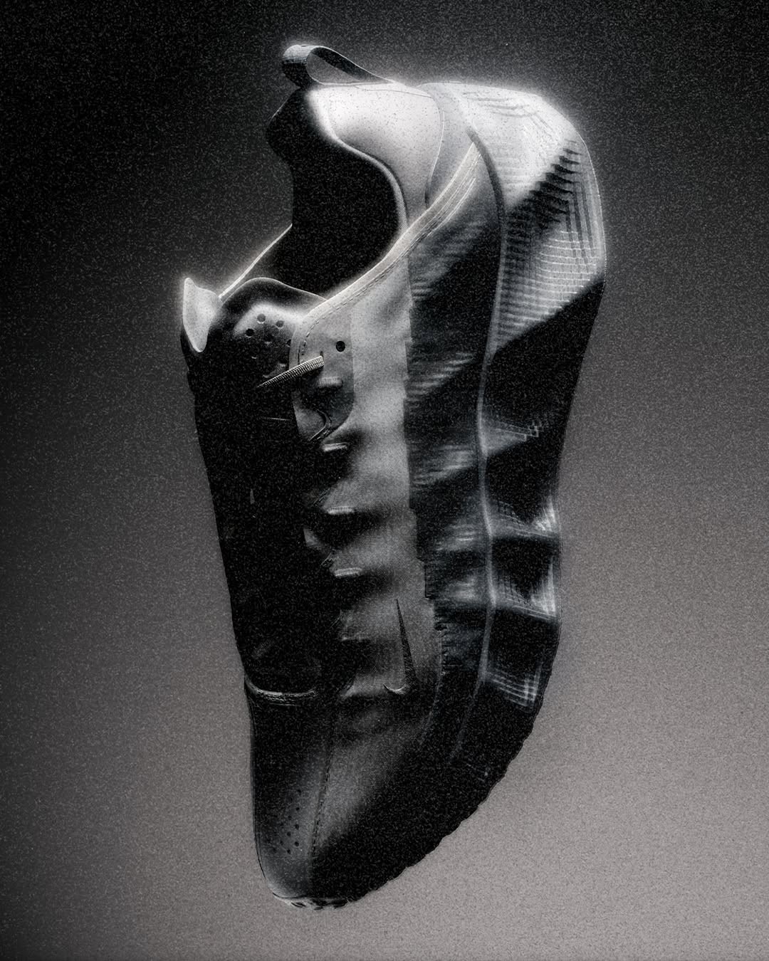 Sculptural dark sneaker with negative space aerodynamic bridge on pale concrete pedestal